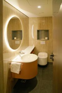马里博尔HABAKUK Wellness & Event Hotel的带浴缸、卫生间和镜子的浴室