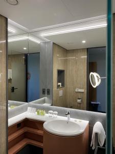 马里博尔HABAKUK Wellness & Event Hotel的一间带水槽和镜子的浴室