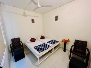 斋浦尔Hostel ivory的一间卧室配有一张床和两把椅子