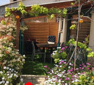 勒卡内Cottage Perla Vita的花园配有桌椅和鲜花