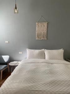台南澄居行旅的卧室配有白色的床和椅子