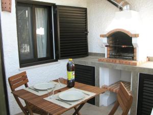 卡巴纳斯·德·塔维拉Almargem Villa 77的一张带两把椅子的木桌和比萨饼烤箱