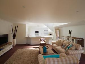 科夫斯港Beachfront Retreat - Ducted Air - Free Wifi的一间带两张沙发的客厅和一间厨房