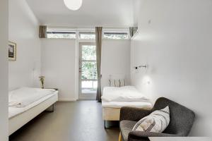 希勒勒希勒勒大宿舍酒店的客房设有两张床、一张沙发和一个窗口。