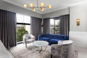 巴科洛德Stonehill Suites的客厅配有蓝色的沙发和椅子