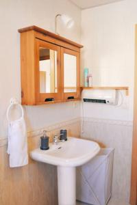 塞维利亚El Apartamento de Trini的一间带白色水槽和木制橱柜的浴室