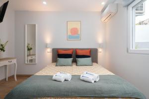 波尔图Charming Bright House w/ Garden的一间卧室配有一张带两个枕头的床