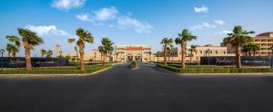 利雅德Radisson Hotel Riyadh Airport的棕榈树建筑前的街道