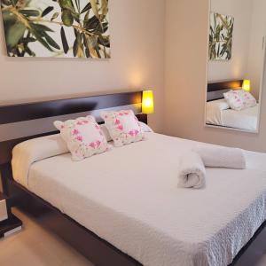 厄尔-汝姆披多Mi casita playera的一间卧室配有带粉色和白色枕头的床
