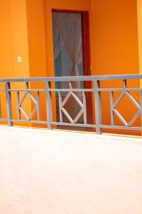 内罗毕Deka Self Contained Rooms的橙色的房子,设有窗户和栅栏