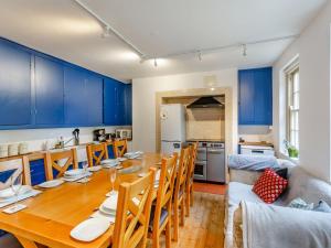 Newton KymeThe Wing At Brook Hall的厨房以及带木桌和蓝色橱柜的用餐室。