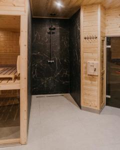 Osiek迪瓦尔酒店的一间设有黑色墙壁淋浴的浴室