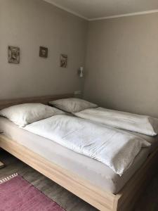 韦茨拉尔Hotel Altstadt Wöllbacher Tor的一间卧室配有两张带白色床单和枕头的床。