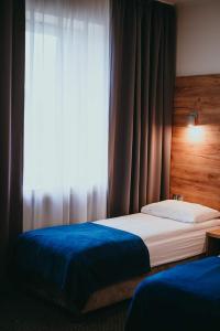 凯尔采S7 Hotel的一间卧室设有两张床和窗户。