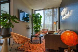 乌尔姆NYCE Hotel Ulm的客厅配有沙发、椅子和植物