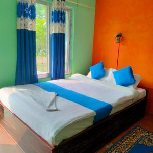 索拉哈Hotel Tiger Tops Sauraha的一间卧室设有一张大床,拥有蓝色和绿色的墙壁