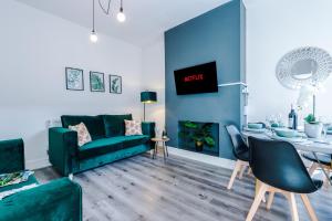 克鲁Spacious 4-bed house in Crewe by 53 Degrees Property, ideal for Business & Contractors - Sleeps 7的客厅配有绿色沙发和桌子