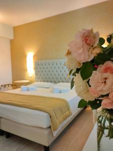 维罗纳新歌剧旅馆的一间卧室,卧室内有一张带粉红色花卉的花瓶床