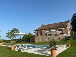 圣西普里安Domaine de Cazal - Gîte 4 pers avec piscine au cœur de 26 hectares de nature préservée的一座带游泳池、椅子和遮阳伞的房子