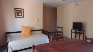 科隆Atalaya的客房设有1张床、1张桌子和1台电视。