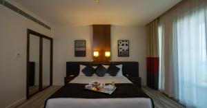 阿布扎比阿布扎比亚斯岛驻桥套房假日酒店的一间卧室配有一张床,上面放着一个食物托盘