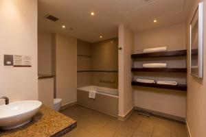 阿布扎比阿布扎比亚斯岛驻桥套房假日酒店的浴室配有盥洗盆、卫生间和浴缸。