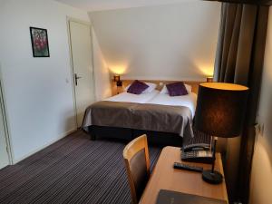 Rossum德盖尔登莫伦酒店的配有一张床和一张书桌的酒店客房