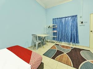 Kampung RajaOYO 90551 Zn Mix Homestay & Roomstay的客房设有床、桌子和窗户。