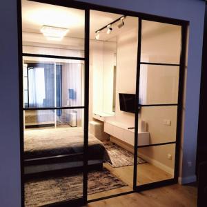 杜尚别Lovely 1-bedroom rental unit in downtown的带镜子的房间和一间带床的卧室
