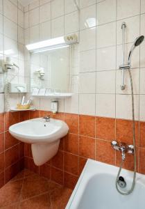 佐洛卡罗斯Hunguest Hotel Freya的浴室配有盥洗盆和浴缸。