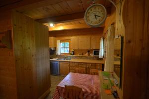 Jaroslavické PasekyMeadow Ranch Holiday Home的厨房配有桌子和天花板上的时钟