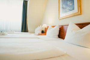 杜塞尔多夫老城圣乔治酒店的配有白色枕头的酒店客房内的两张床