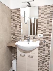 尼科洛西Dove nasce il Sole B&B的浴室设有白色水槽和镜子