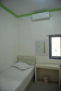 帕卢Penginapan AIRA的小房间设有床和窗户