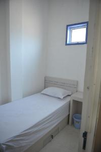 帕卢Penginapan AIRA的卧室配有白色的床和窗户