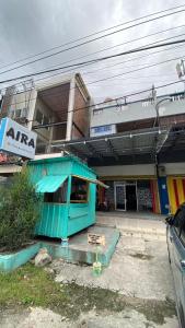 帕卢Penginapan AIRA的前面有蓝色的棚屋的建筑