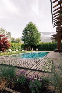 坎波图雷斯Gasthof Residence Brugghof & Erlhof的庭院中带木甲板的游泳池