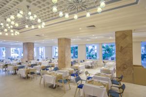 哈马马特Royal Azur Thalassa的餐厅设有白色的桌椅和窗户。