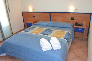 米兰依丽德酒店的一张蓝色的床,上面有两条白色的毛巾