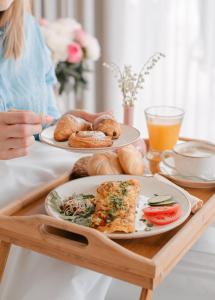 格丁尼亚Moje Orłowo Boutique Bed & Breakfast - Adults Only的坐在餐桌旁的女人,有两盘食物
