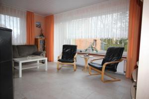 多尔努姆Ferienhaus Brigitte的客厅配有两把椅子、一张桌子和一扇窗户