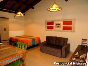 加罗帕巴Residencial Hibiscos - Vista Mar的客厅配有沙发和1张床