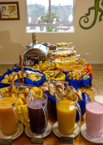 坎波斯杜若尔当Pousada Kaliman Luxo的一张桌子,上面放着一大堆食物和橙汁