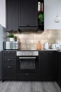 波尔顿乐法尔德Beautiful first floor apartment的厨房配有黑色橱柜和黑色烤箱