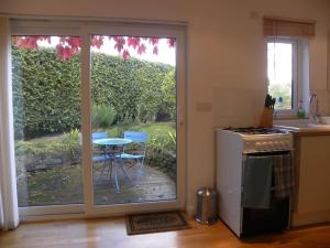 Saint DominickOakey Orchard - cosy apartment in Tamar Valley, Cornwall的厨房设有滑动玻璃门,可通往庭院。