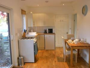 Saint DominickOakey Orchard - cosy apartment in Tamar Valley, Cornwall的厨房配有桌子和炉灶。 顶部烤箱