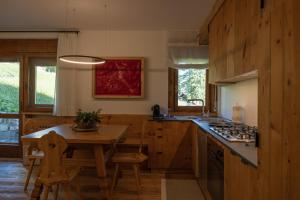 科尔蒂纳丹佩佐Casa Betulla的厨房配有木桌、木桌和椅子