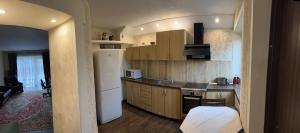 考纳斯ARB Kaunas的厨房配有木制橱柜和白色冰箱。