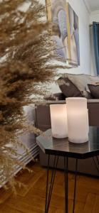 塞萨洛尼基Porto Sea View Apartments - Pl Ippodromiou 21的客厅桌子上的两把白蜡烛