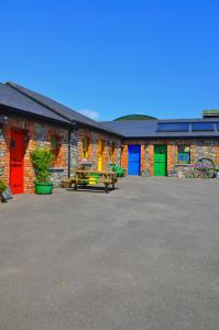 斯莱恩Slane Farm Hostel, Cottages and Camping的一组拥有色彩缤纷的门和桌子的建筑